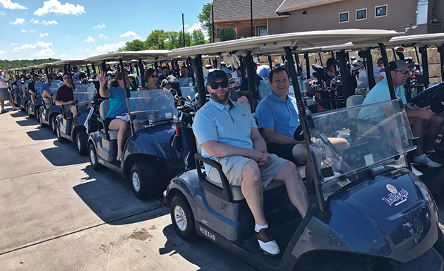 Kristian Thonvold (left) and Rick Huston ride in a golf cart at the Hudson Hospital Golf Tournament