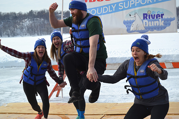 Four people jump into the water at the St. Croix River Dunk