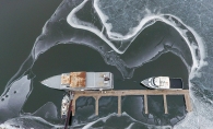 Boats surrounded by ice on the water on the St. Croix River at the Hudson Dike