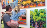 A father and daughter admire art at the Spirit of the St. Croix Art Festival, one of many local fall art festivals.