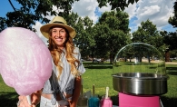 Sarah Kubler, founder of Confection Cotton Candy, stands by a cotton candy cart, available for events in Wisconsin and Minnesota.