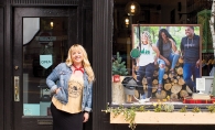 Sarah Schroeder, founder of Minnesota Made apparel company, poses outside a storefront displaying some of her products