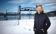 Charlene Roise, author of The Saga of the Stillwater Lift Bridge,  stands with the bridge in the background.