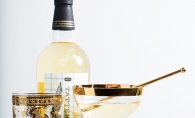 A bottle of liquor from Tattersall Distilling sits on a bar cart with an aperitif.