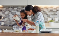 A mother and child cook together.