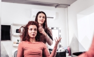 A woman talks to her hairstylist while getting a haircut.