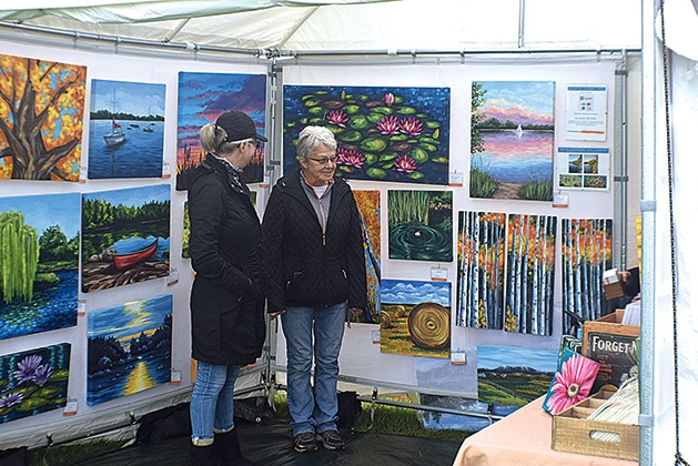 Attendees look at art at the Rivertown Fall Art Festival 2019