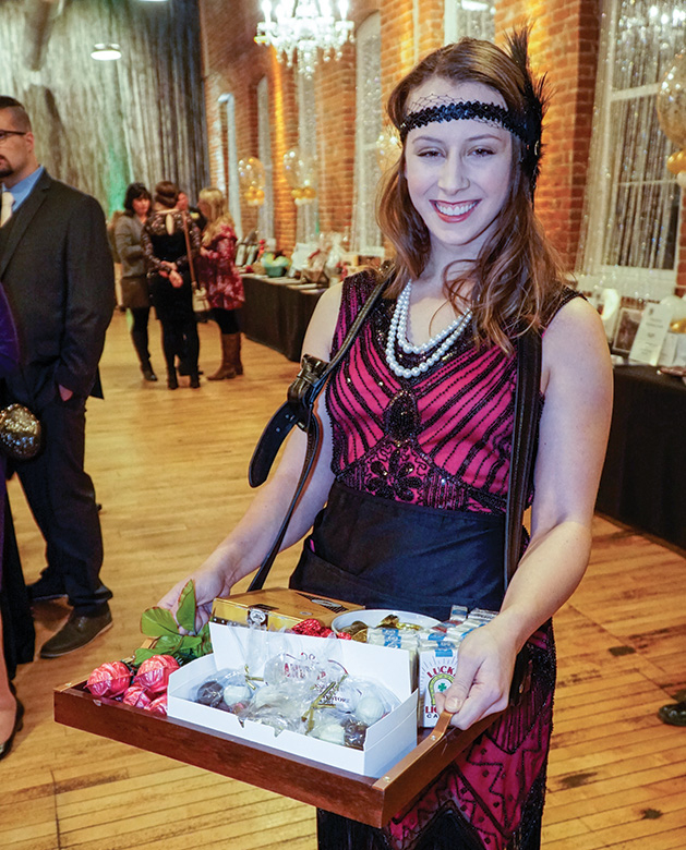 A woman holds goodies from the Zephyr Theatre at the Stillwater Chamber Gala.