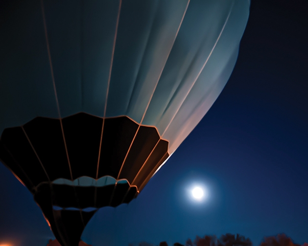 Hot air balloon illuminated by moonlight