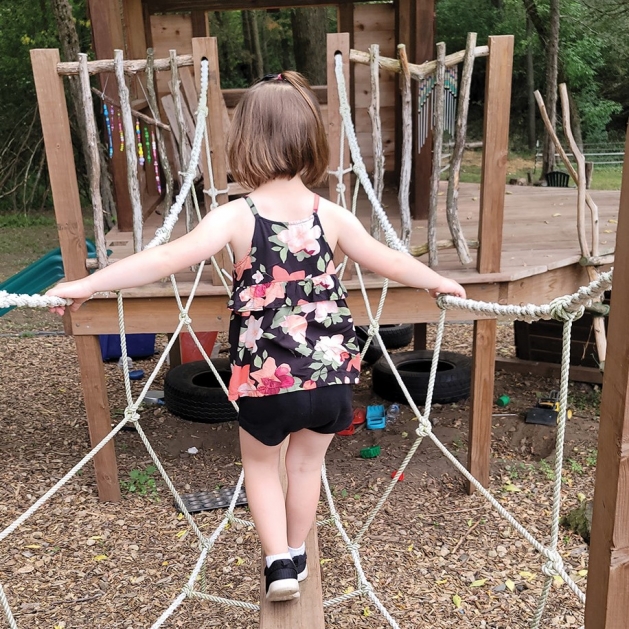 Little girl playing on the playground at HOPE Grove.