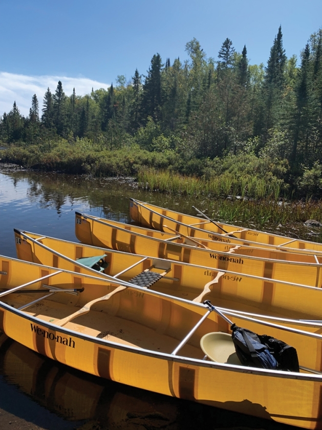 Yellow canoes lines up on a lake.