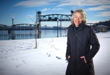 Charlene Roise, author of The Saga of the Stillwater Lift Bridge,  stands with the bridge in the background.