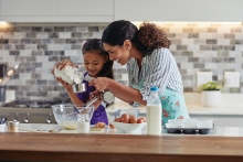 A mother and child cook together.