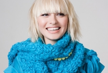 A blonde woman wearing a blue scarf.