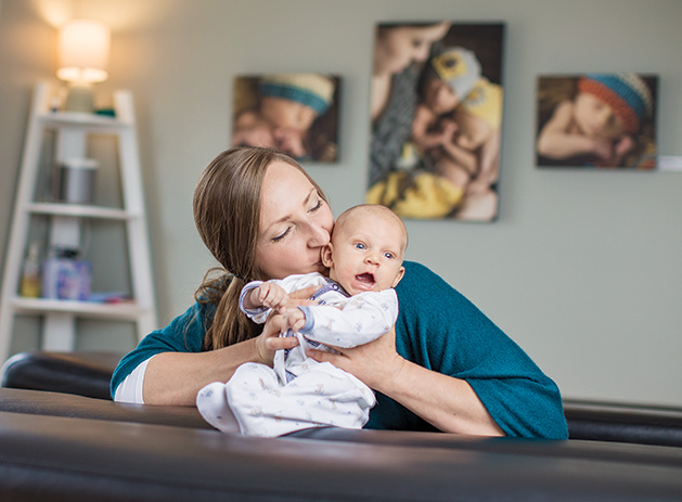 A chiropractor kisses a baby at Revival Chiropractic in Stillwater. 