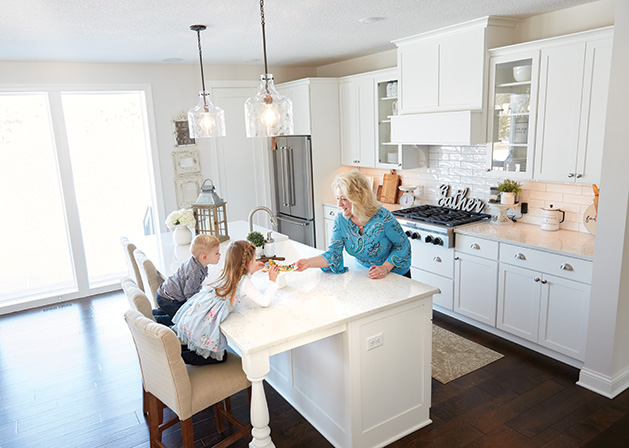 Nancy Eike plays with her grandchildren in the kitchen of her Stillwater home.